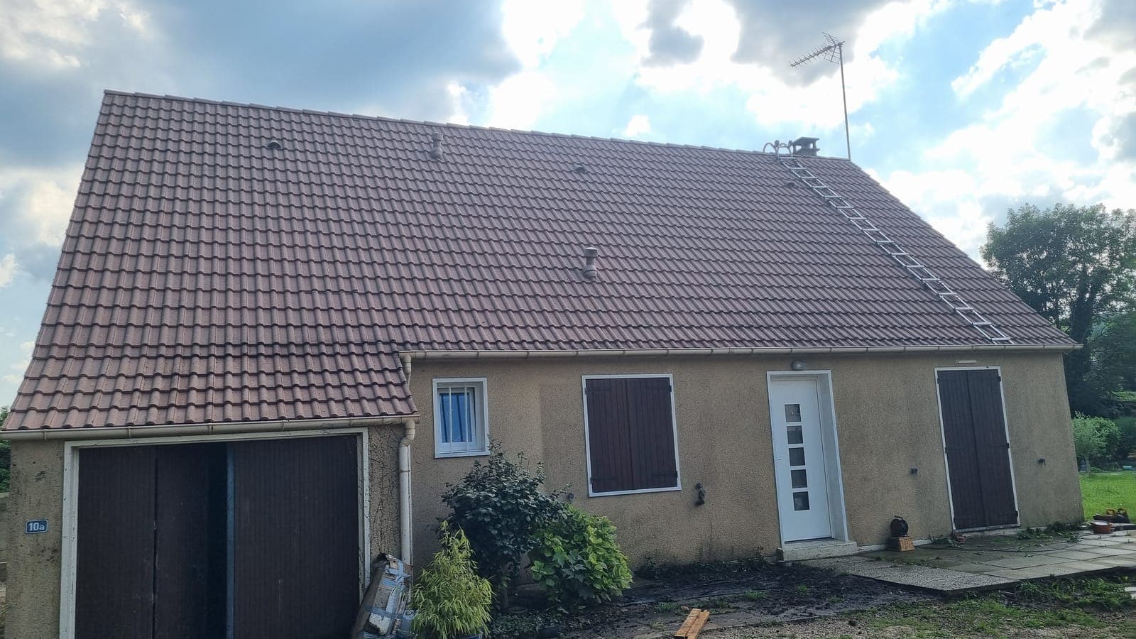Longère basse à portes de grange sous une toiture en tuiles brunes neuves