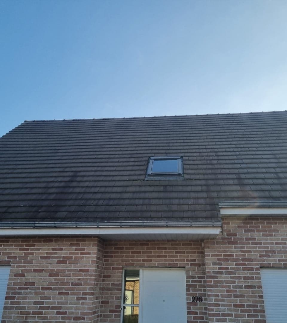 Toiture d'une maison en brique noircie avant nettoyage