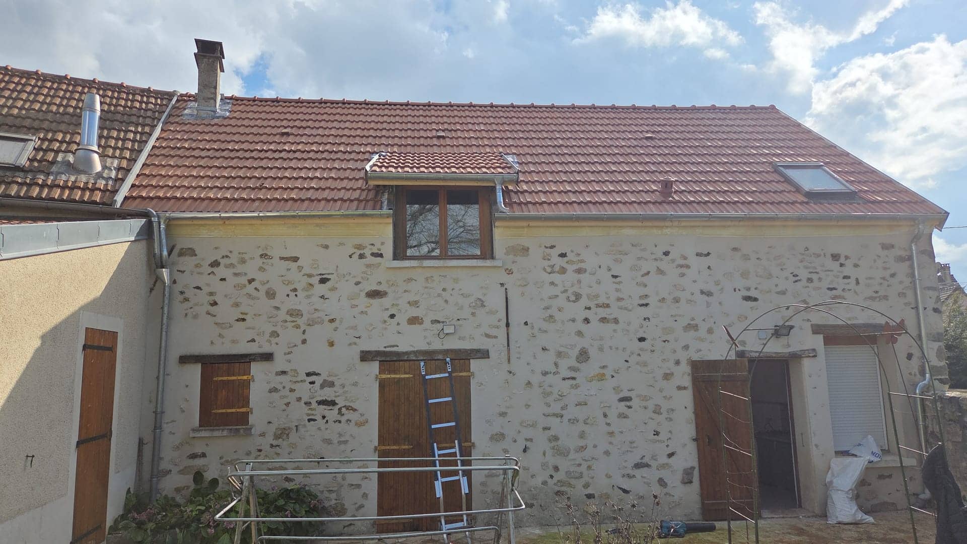 Maison en pierre sous une toiture en tuiles neuves, chantier de A2SR Couverture